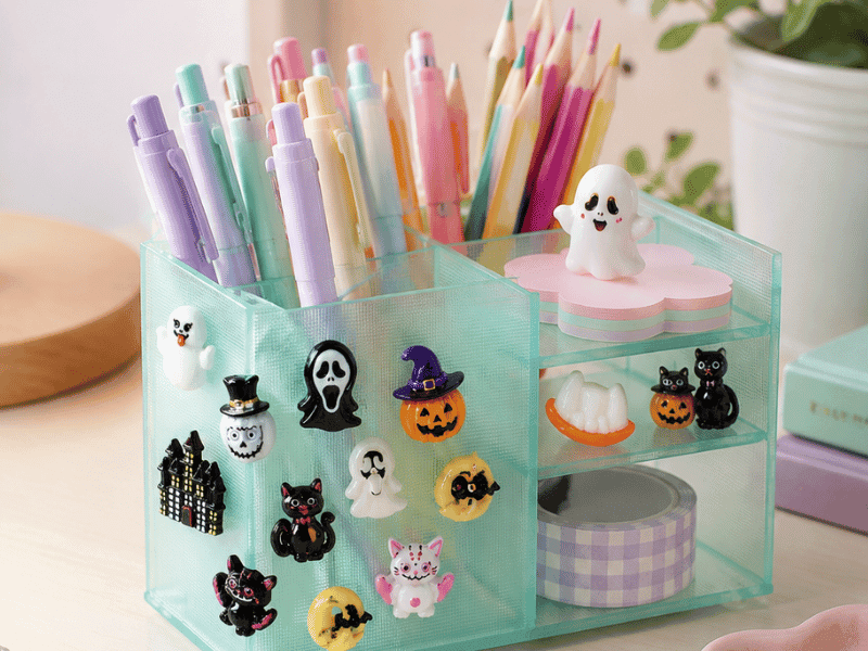 Pastel desk organizer decorated with cute Halloween resin charms, including ghosts, pumpkins, black cats and witch hats.