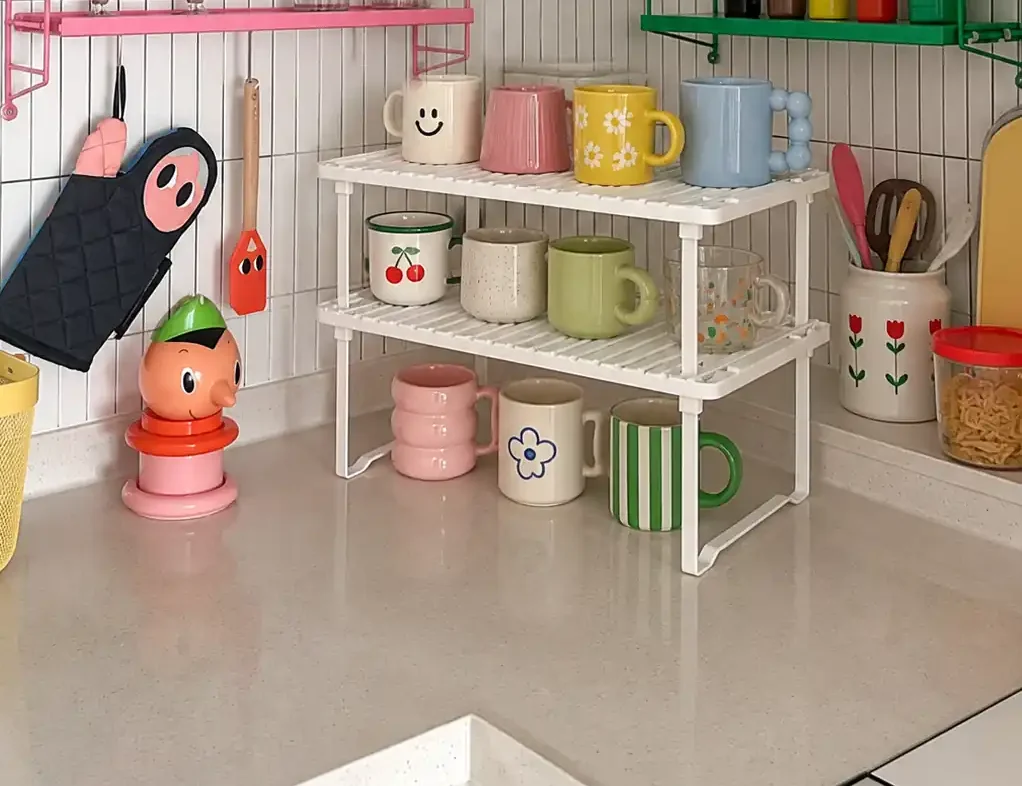 Countertop mug storage shelf holding colorful coffee mugs in a small kitchen corner