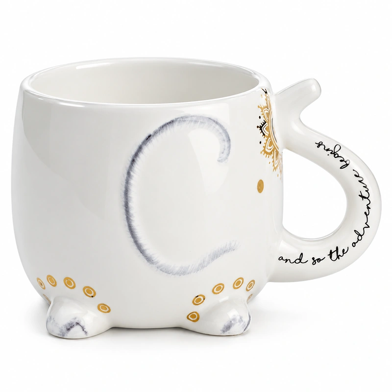 White ceramic cat-shaped mug with gray tail design, gold accents and curved script handle.
